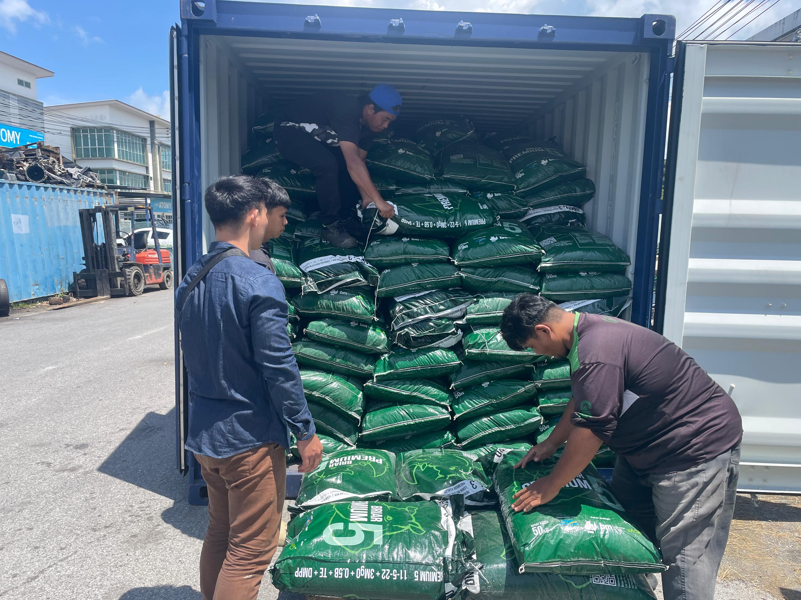 workers unstuffing packages from container